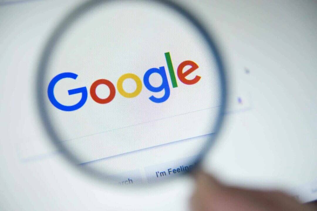 The Google homepage on a screen under a magnifying glass